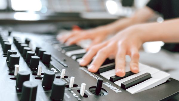 Bild på händer som spelar på en synth