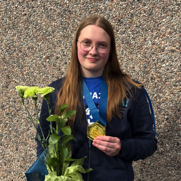Malena Björkström med guldmedalj och blommor