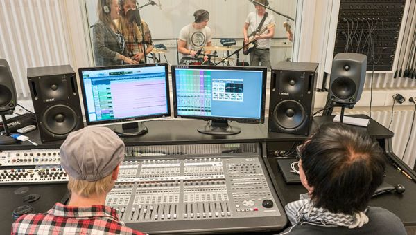 en inspelningsstudio med mixare och musikanter